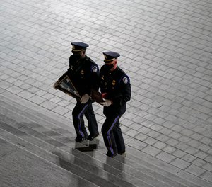 An honor guard carries an urn with the cremated remains of U.S. Capitol Police officer Brian Sicknick and folded flag up the steps of the U.S Capitol to lie in honor in the Rotunda, Tuesday, Feb. 2, 2021, in Washington.