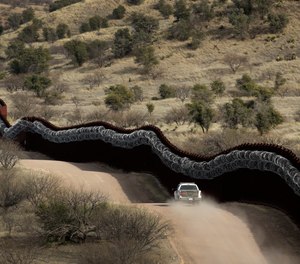 This March 2, 2019 photo shows a Customs and Border Control agent patrolling on the US side of the border wall along the Mexico east of Nogales, Ariz.