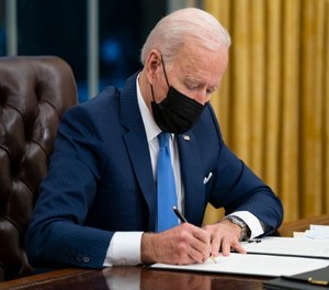 President Joe Biden signs an executive order on immigration in the Oval Office of the White House in Washington.
