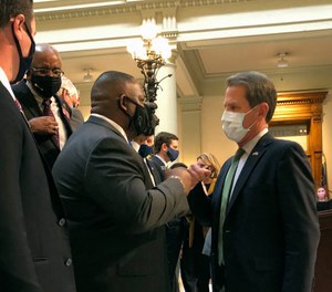 Georgia Gov. Brian Kemp, right, bumps fists with Democratic state Rep. Carl Gilliard of Garden City on Tuesday, Feb. 16, 2021, at the state Capitol in Atlanta.