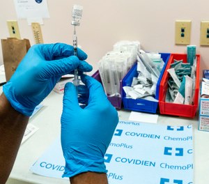 A pharmacist prepares a syringe with the Pfizer-BioNTech COVID-19 vaccine.
