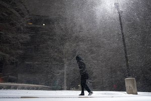In this Feb. 14, 2021, file photo, woman walks through falling snow in San Antonio. A recently released study found that extreme temperatures may increase the risk of dying for people with cardiovascular disease, especially those with heart failure.