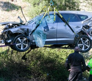 A crane is used to lift a vehicle following a rollover accident involving golfer Tiger Woods, Tuesday, Feb. 23, 2021, in the Rancho Palos Verdes suburb of Los Angeles.