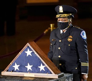 In this Feb. 2, 2021 file photo, acting U.S. Capitol Police Chief Yogananda Pittman pays respects to U.S. Capitol Police officer Brian Sicknick in the Capitol Rotunda in Washington.