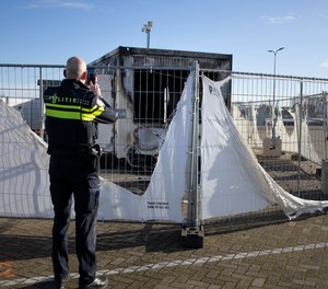 A police officer photographs a burned-out COVID-19 testing facility in a village in the Netherlands on Jan. 24, 2021. A new report by researchers in California and Geneva, Switzerland found that about 400 attacks on healthcare workers globally were motivated by fears and frustration over COVID-19.