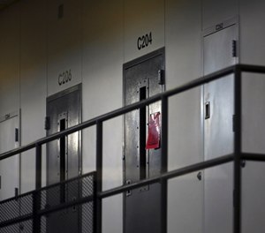 A red tag hangs on a cell door, signifying an active COVID-19 case.