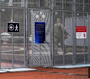 A National Guard soldier walks inside the fenced-off plaza of the Hennepin County Government Center, Wednesday, March 10, 2021, in Minneapolis where the trial for former Minneapolis police officer Derek Chauvin continues with jury selection.