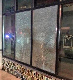 This Friday, March 12, 2021, photo released by Portland Police Bureau shows shmashed windows left behind by people inside the perimeter of a march by a group of about 100 hundred protesters Friday night in Portland, Ore.