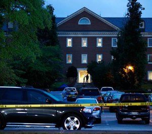 A law enforcement official stands at an entrance to a municipal building that was the scene of a shooting in Virginia Beach, Va.