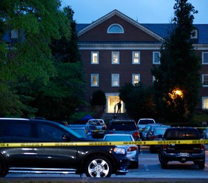 In this Saturday, June 1, 2019 file photo, a law enforcement official stands at an entrance to a municipal building that was the scene of a shooting in Virginia Beach, Va.