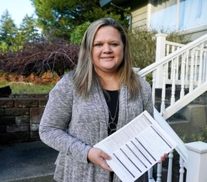 State Rep. Tarra Simmons holds blank voter registration forms as she poses for a photo at her home in Bremerton, Wash.