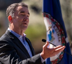 In this March 30, 2021, file photo, Virginia Gov. Ralph Northam speaks at a news conference to announce the expansion of commuter rail in Virginia at the Amtrak and Virginia Railway Express (VRE) Alexandria Station, in Alexandria, Va.