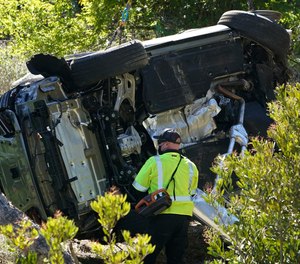 In this Feb. 23, 2021, file photo a vehicle rests on its side after a rollover accident involving golfer Tiger Woods, in Rancho Palos Verdes, Calif., a suburb of Los Angeles.
