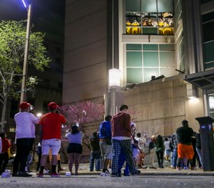 Onlookers watch from the street as inmates chant and throw things from broken windows at the St. Louis Justice Center.