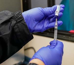 A nurse fills a syringe with a dose of Johnson & Johnson's COVID-19 vaccine in Uniondale, N.Y.