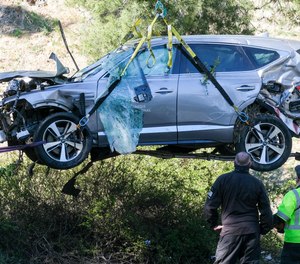 A crane is used to lift a vehicle following a rollover accident involving golfer Tiger Woods, Tuesday, Feb. 23, 2021, in the Rancho Palos Verdes suburb of Los Angeles.
