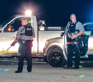 Police officers stand at the scene following a police pursuit Monday, April 12, 2021, in Carroll County, Ga.