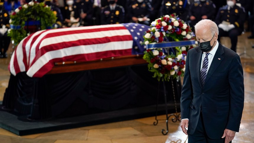 President Joe Biden stands as a joint services honor guard carries the flag-draped casket of U.S. Capitol Police officer William "Billy" Evans, to where he will lie in honor at the Capitol in Washington, Tuesday, April 13, 2021.