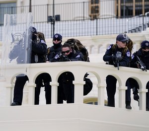 Police keep a watch on demonstrators who tried to break through a police barrier, Wednesday, Jan. 6, 2021, at the Capitol in Washington.