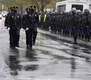 Pallbearers from the U.S. Capitol Police, left, process past Massachusetts state police, right, as they approach St. Stanislaus Kostka Church before a funeral Mass for William