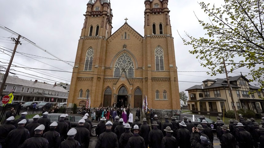 Members of the Massachusetts state police, below, line the street as mourners for the late U.S. Capitol Police officer William "Billy" Evans, depart St. Stanislaus Kostka Church following a funeral Mass, in Adams, Mass., Thursday, April 15, 2021.