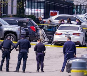 Law enforcement confer at the scene, Friday, April 16, 2021, in Indianapolis, where multiple people were shot at a FedEx Ground facility near the Indianapolis airport.