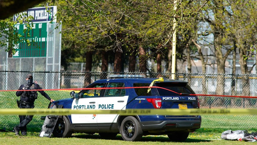 A Portland Police officer stand by following a police involved shooting of a man at Lents Park, Friday, April 16, 2021, in Portland, Ore.