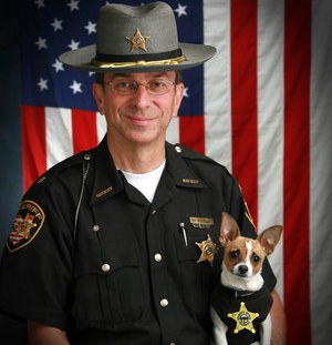 This 2006 image shows then Sheriff Dan McClelland and his small police dog Midge at the Geauga County, Ohio, sheriff's department. Both died on Wednesday, April 14, 2021.