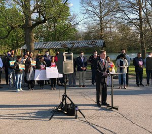Indianapolis Mayor Joe Hogarth speaks at a vigil Saturday, April 17, 2021 in Indianapolis to memorialize the eight people killed in the mass shooting at a FedEx warehouse. Behind him, members of the Sikh community, whose loved ones were killed, hold signs demanding policymakers make gun law reforms in the wake of the shooting.
