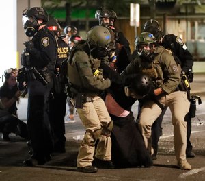 In this July 29, 2020, file photo, federal officers arrest a demonstrator during a Black Lives Matter protest at the Mark O. Hatfield United States Courthouse in Portland, Ore.