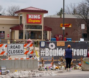 Tributes cover the temporary fence around the King Soopers grocery store in which 10 people died in a mass shooting in late March on Friday, April 23, 2021, in Boulder, Colo.