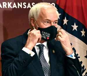 This July 20, 2020 file photo shows Arkansas Gov. Asa Hutchinson removes at a briefing at the state capitol in Little Rock.