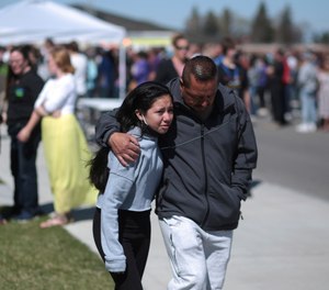 People embrace after a school shooting at Rigby Middle School in Rigby, Idaho on Thursday, May 6, 2021.
