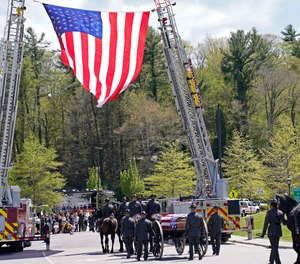 A processional approaches the Holmes Convocational Center for the funeral services of Watauga County Sheriff's Deputies Sgt. Chris Ward and K-9 Deputy Logan Fox in Boone, N.C., Thursday, May 6, 2021.