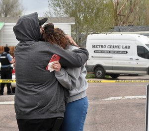 Freddy Marquez kisses the head of his wife, Nubia Marquez, near the scene where her mother and other family members were killed in a mass shooting early Sunday, May 9, 2021, in Colorado Springs, Colo.