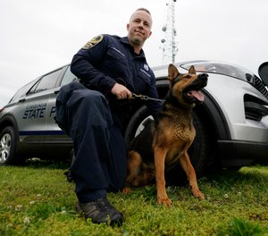Virginia State Police K-9 officer Tyler Fridley, poses with his dog Aries at State Police headquarters in Richmond, Va., Monday, May 10, 2021.