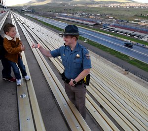 Colorado State Patrol Trooper Josh Lewis fist bumps 3-year-old Lincoln Delagarza, of Northglenn, Colorado, before racing begins at Bandimere Speedway west of Denver on May 5, 2021.