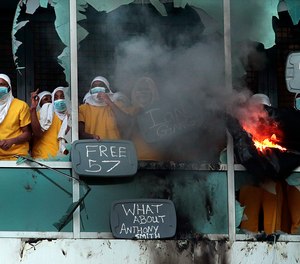 In this Feb. 6, 2021, file photo, inmates yell from broken windows at the St. Louis Justice Center during the first of two major uprisings in recent months at the facility.