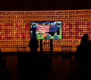Relatives and law enforcement officers watch a virtual ceremony honoring the fallen law enforcement officers from 2020 during a reception commemorating the National Police Week at the National Law Enforcement Museum in Washington, Thursday, May 13, 2021.