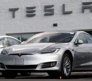 This July 8, 2018 photo shows a Tesla 2018 Model 3 sedans sitting on display outside a Tesla showroom in Littleton, Colo.