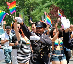 In this Sunday, June 29, 2014 file photo, NYPD police officers march along Fifth Avenue during the gay pride parade in New York. Organizers of New York City’s Pride events said Saturday, May 15, 2021 they are banning police and other law enforcement from marching in their huge annual parade until at least 2025 and will also seek to keep on-duty officers a block away from the event.