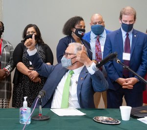 Washington Gov. Jay Inslee thanks state Rep. Jesse Johnson after signing legislation Johnson sponsored - one of 12 bills about police accountability and reform signed by the governor - during a ceremony at the Eastside Community Center in Tacoma, Wash., on Tuesday, May 18, 2021.
