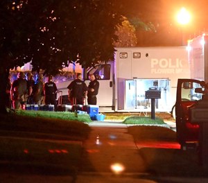 Police officers stand near the scene where three officers were fired upon late Wednesday, May 26, 2021, in Flower Mound, Texas.