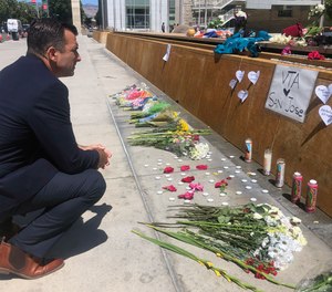 San Jose Mayor Sam Liccardo stops to view a makeshift memorial for the rail yard shooting victims in front of City Hall in San Jose, Calif., on Thursday, May 27, 2021.