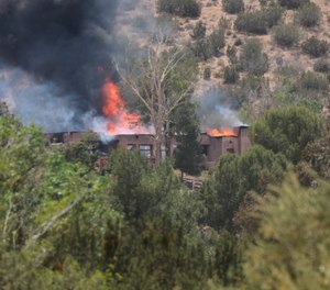 A fire engulfs a house in Acton, Calif., Tuesday, June 1, 2021.
