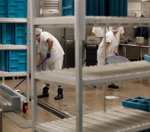 Workers are shown in the kitchen of the U.S. Immigration and Customs Enforcement detention facility in Tacoma, Wash.