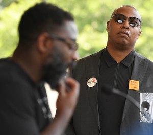 Former UConn and NBA star Caron Butler listens as poet and advocate Reginald Dwayne Betts speaks at a news conference at the Connecticut State Capitol on Monday to urge Gov. Ned Lamont to sign legislation that strictly limits the use of solitary confinement and other forms of inmate isolation in prisons.