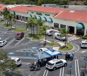 Police gather at the Publix shopping center at the scene of a shooting in Royal Palm Beach, Fla., on Thursday, June 10, 2021.