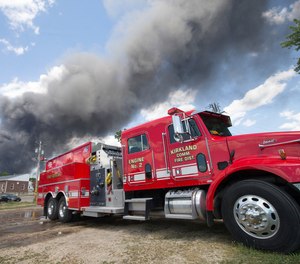 Firefighters from Kirkland Community Fire Protection District Engine 2 attach hoses to tanker trucks to refill them with water from the Rock River at the Rockton Hydroplant Monday, June 14, 2021, in Rockton.