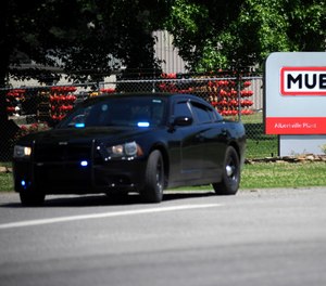 A police car guards the entrance to a Mueller Co. fire hydrant plant where police said multiple people were shot to death and others were wounded in Albertville, Ala., on Tuesday, June 15, 2021.